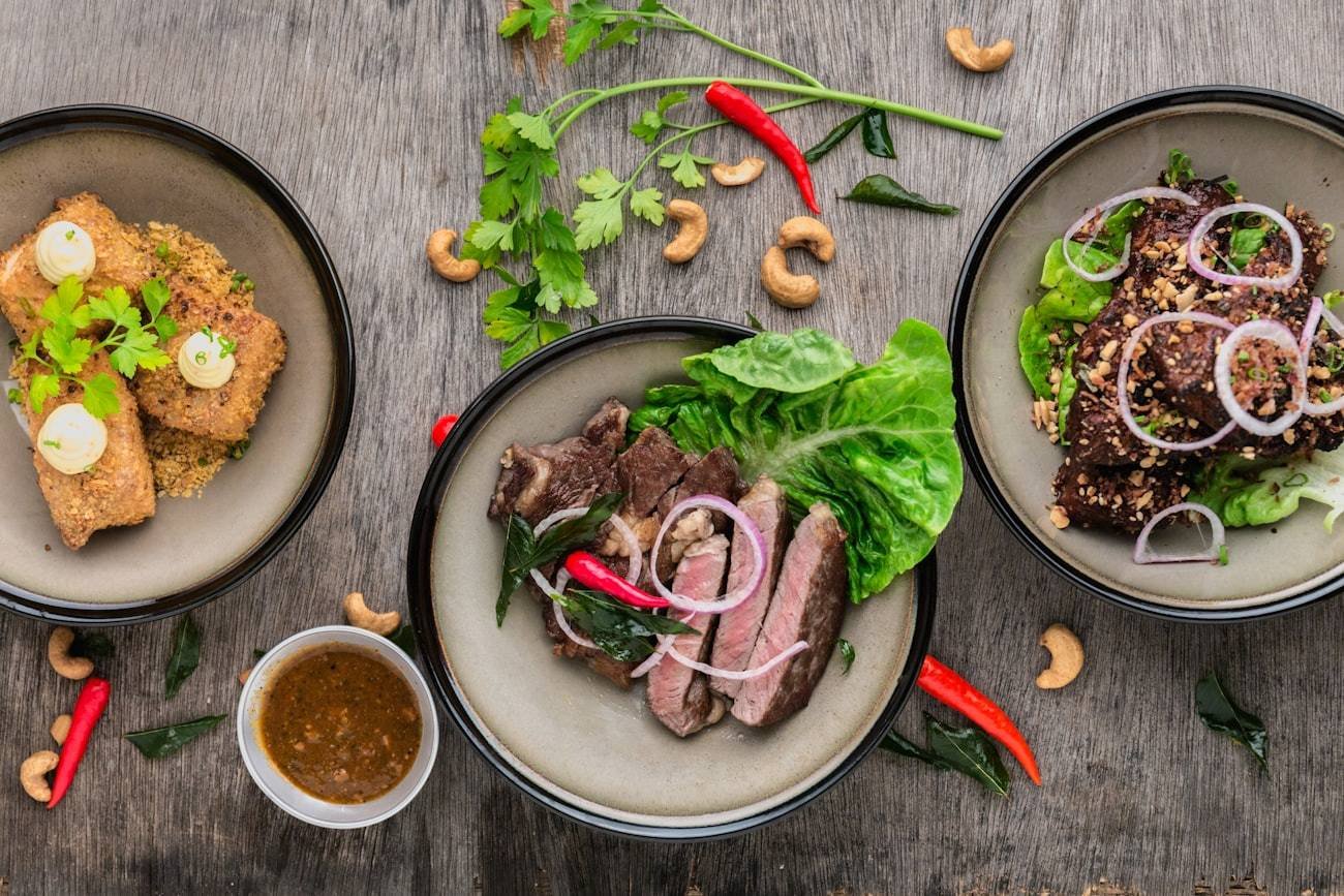 Plates of grilled food and salads shared across a table